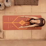 Kadın, toprak tonlu mozaik desenli çevre dostu yoga matında esneme hareketi yapıyor.