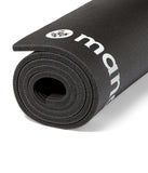 ENDURA 10mm siyah fitness matı, rulo halinde, Manduka logosu görünür.