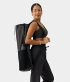 Kadın siyah Manduka Hala Mat Carrier / Phantom Go Steady 3.0-BLACK mat çantasını sırtında taşıyor, astarlı geniş bölme.