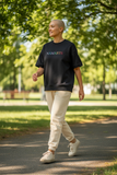 Namaste Oversize T-shirt siyah, unisex oversize, rahat kesim, parkta yürüyen kişi